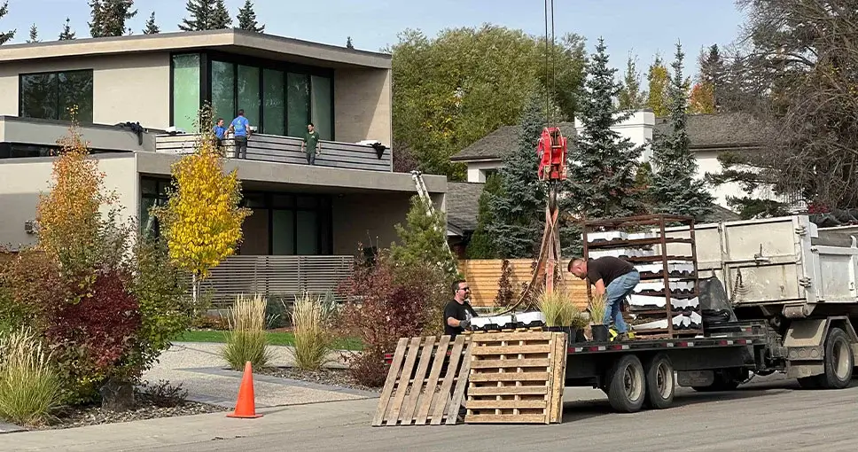 Construction site with workers, a truck, and a modern house in the background.