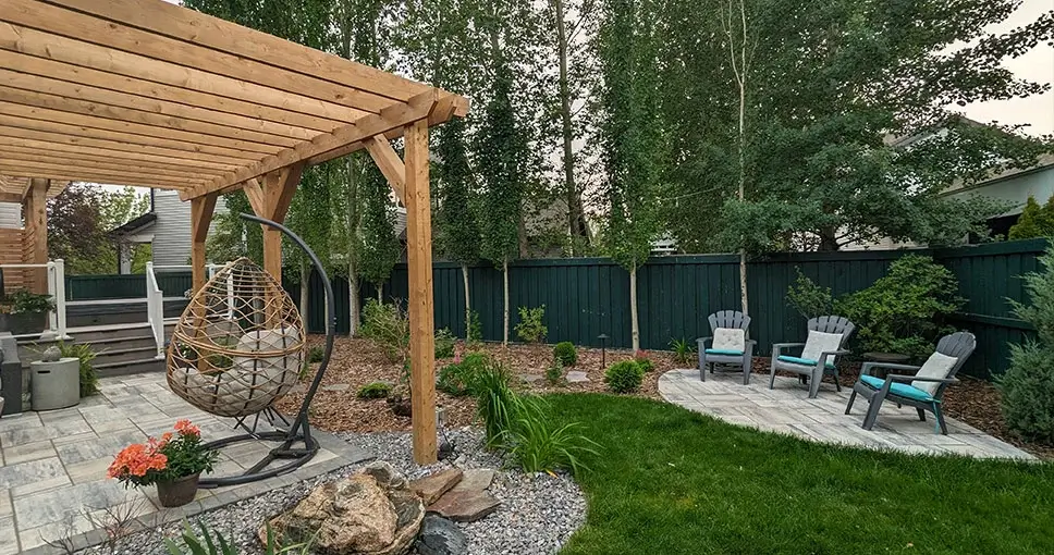 Backyard with pergola, hanging chair, and patio furniture.