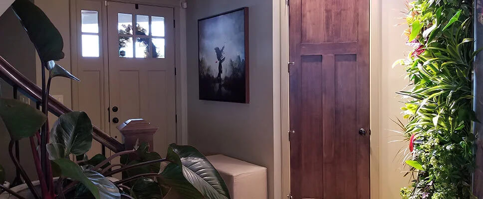 Edmonton home entryway with vertical green wall, leafy plants, and wreath-adorned door.