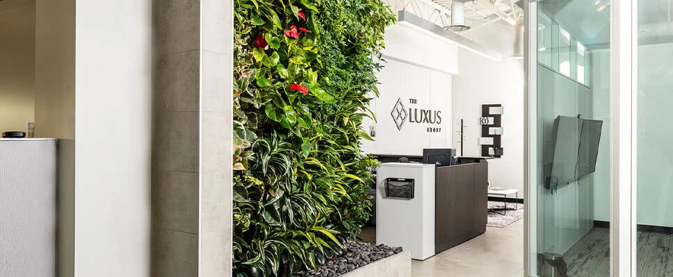 Edmonton office reception with vertical green wall, glass meeting room, and modern desk.