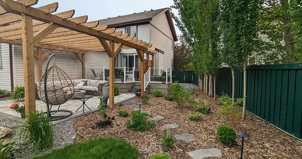 Wooden pergola over patio with hanging chair, side view.