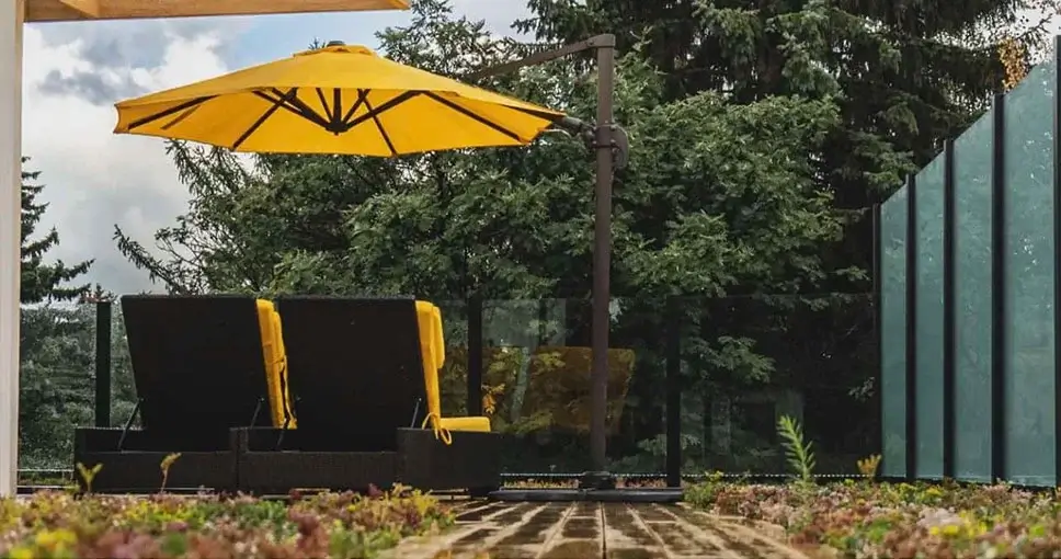 Outdoor patio with yellow umbrella and lounge chairs.