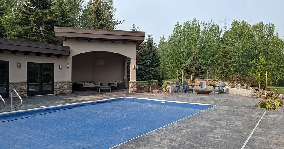 Outdoor pool area with a covered lounge and fire pit.