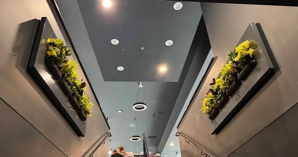 Vertical wall planters with greenery on a staircase.