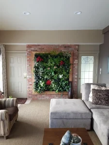 A wood-framed vertical plant wall installed on an exposed red brick wall in a modern living room.