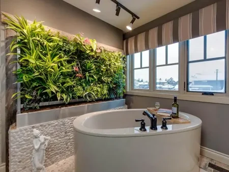 A lush vertical living wall installed behind a modern freestanding bathtub in a luxury bathroom.
