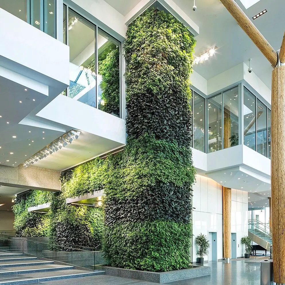 A large, multi-story vertical garden or living wall inside a bright, modern building lobby with glass balconies.
