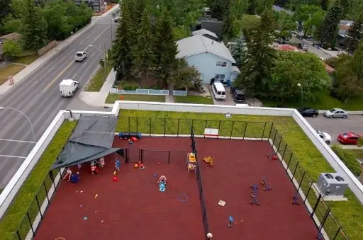 Aerial view of a red rooftop playground with a green roof border.