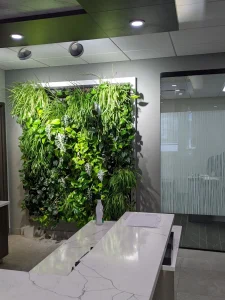 Large vertical living wall behind a marble reception desk.