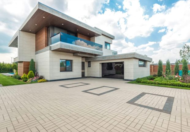 a modern two-story house with a driveway and a brick facade.