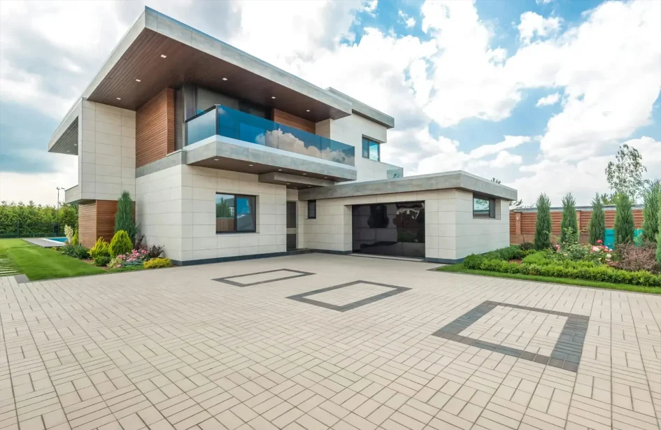 a modern two-story house with a driveway and a brick facade.