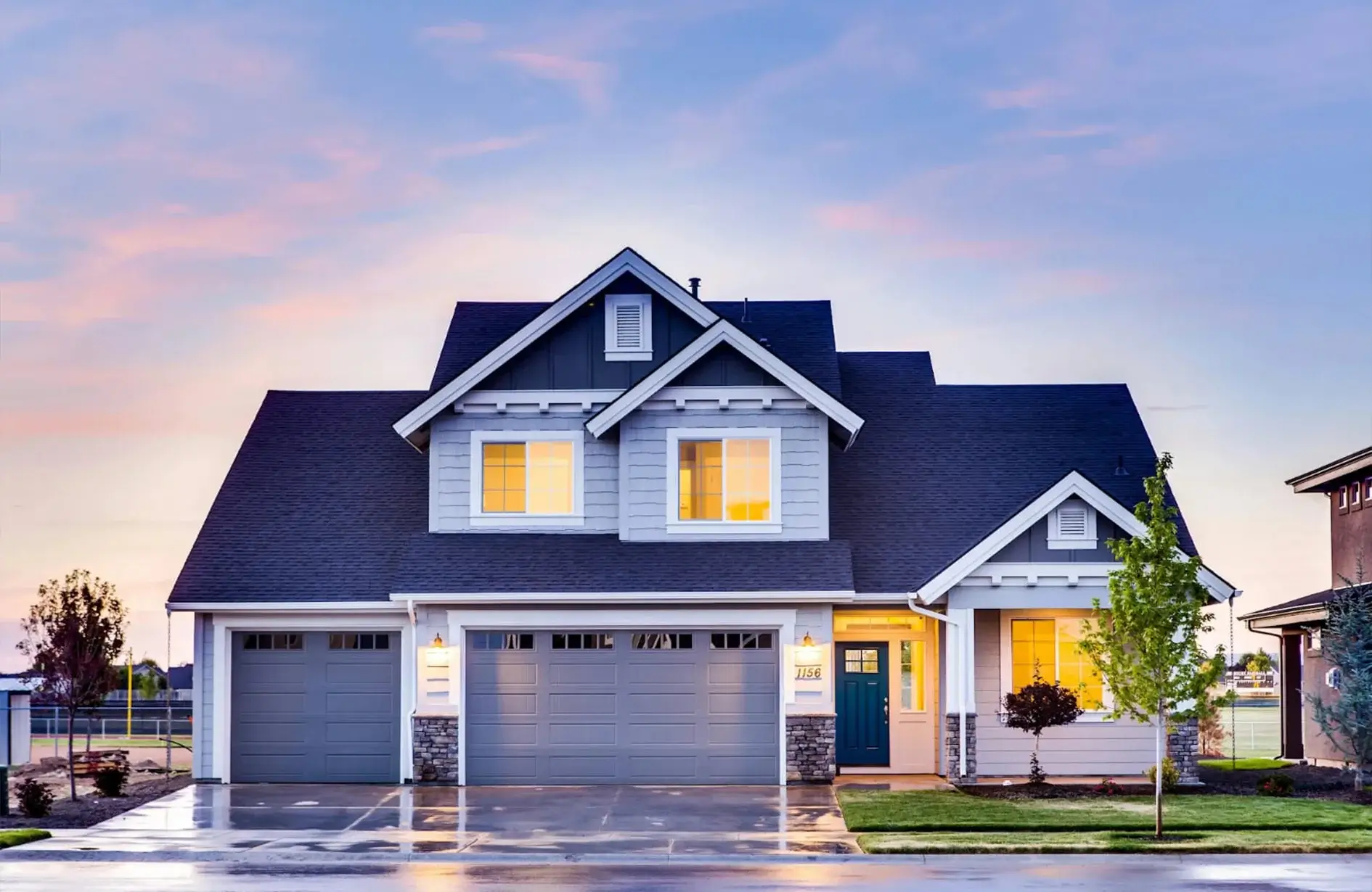 A residential house, prominently featuring its garage doors. 