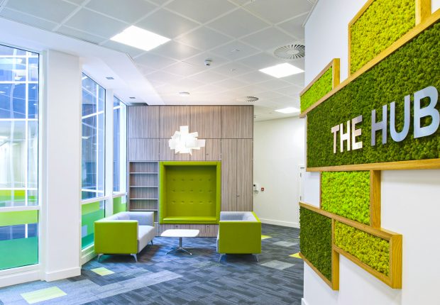 Modern Edmonton office lobby with natural moss wall decor and 'THE HUB' sign.