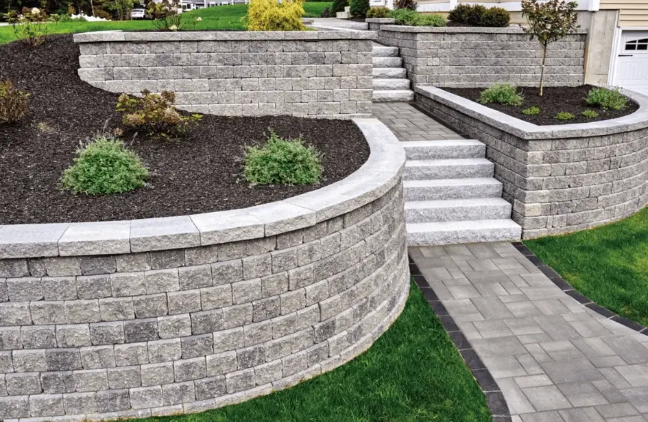 Curved terraced stone retaining wall with steps and plants in Edmonton residential yard