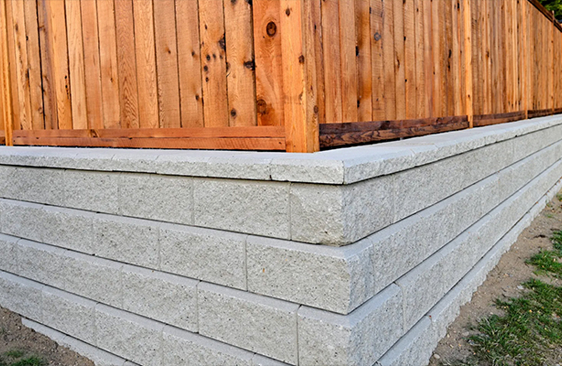 Wood fence built on concrete retaining wall outdoors